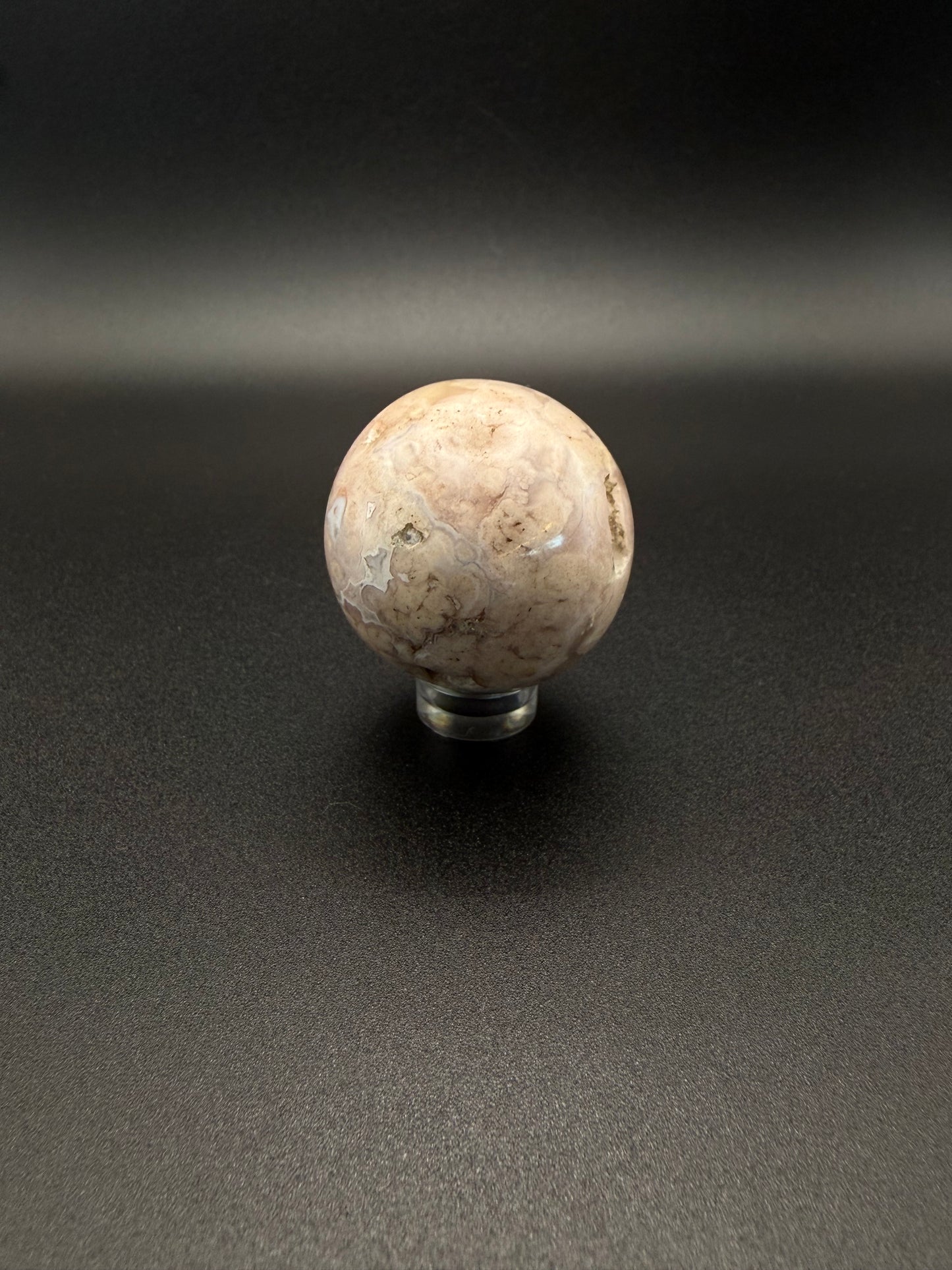 Flower agate polished crystal in the shape of a sphere.