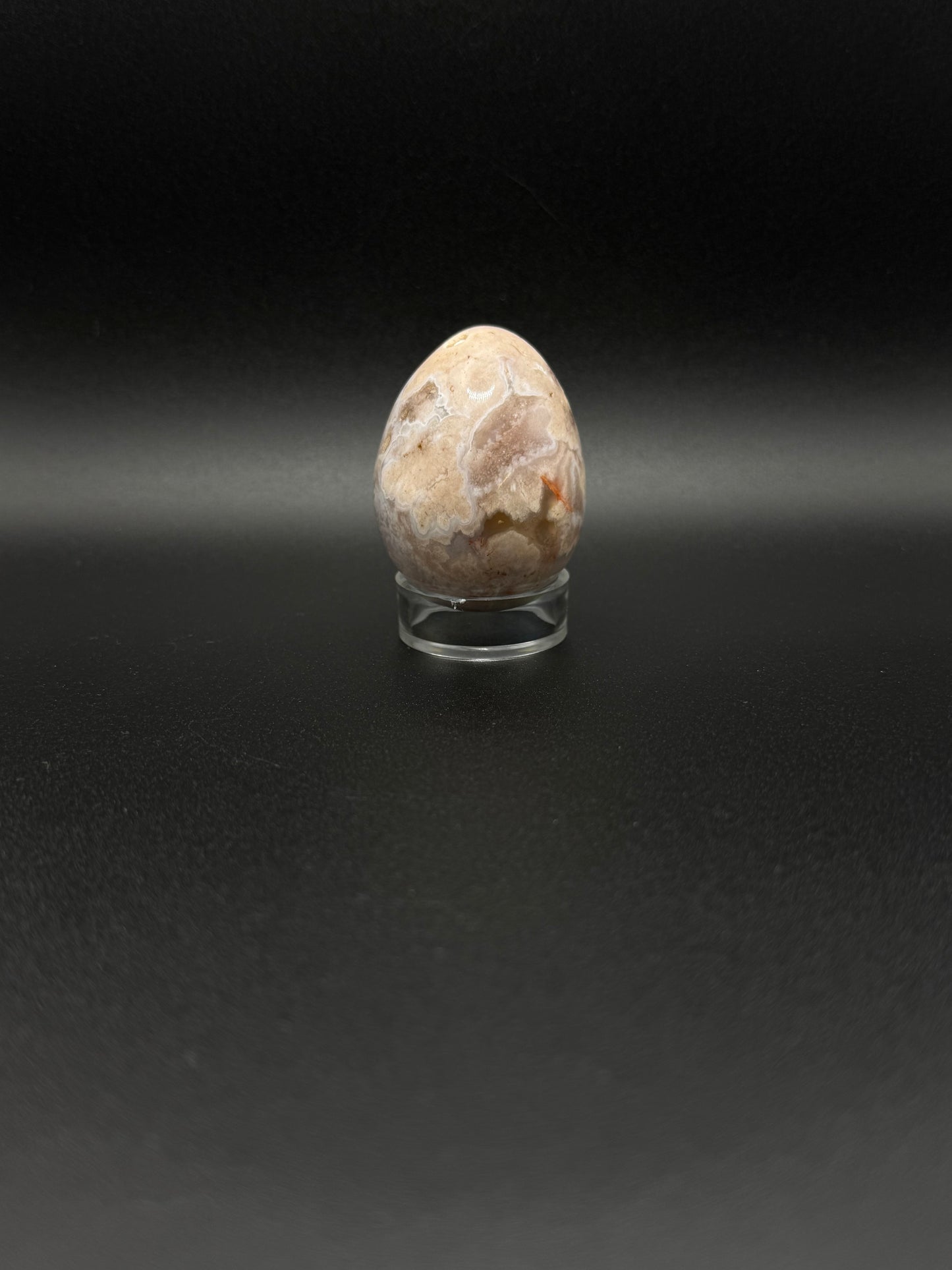Polished flower agate crystal in the shape of an egg.