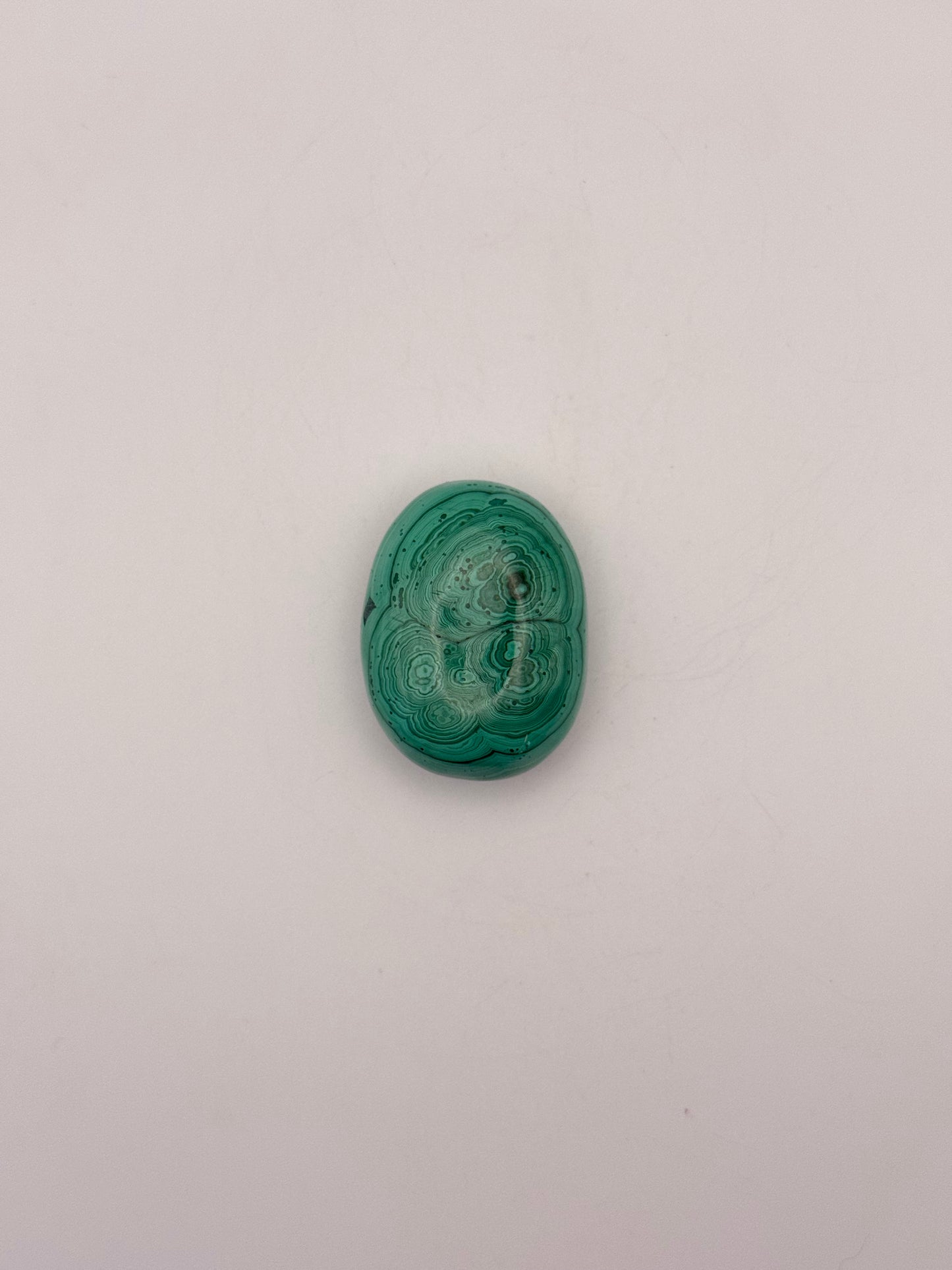 Vibrant green malachite palm stone with unique swirling patterns.