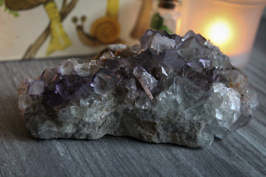 Raw fluorite crystal cluster with purple and green color.