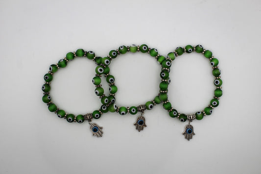 Green evil eye bracelets with a hanging evil eye pendant attached.