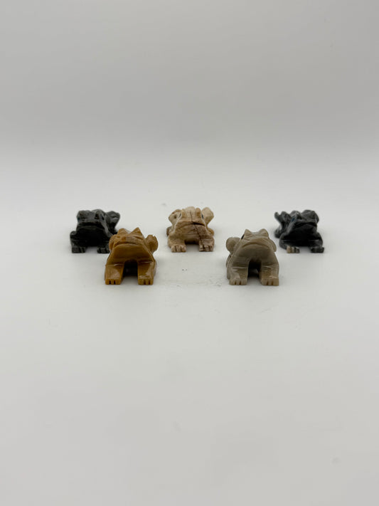 Five small stone sculptures of animals arranged vertically on a white background