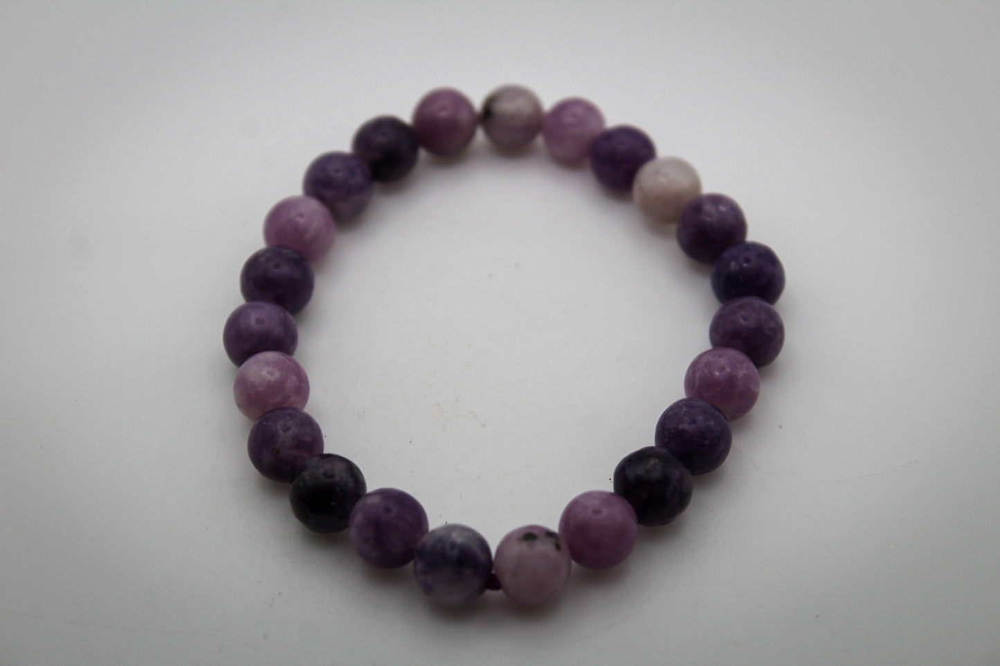 A bracelet made of purple lepidolite gemstone beads that are 8mm.