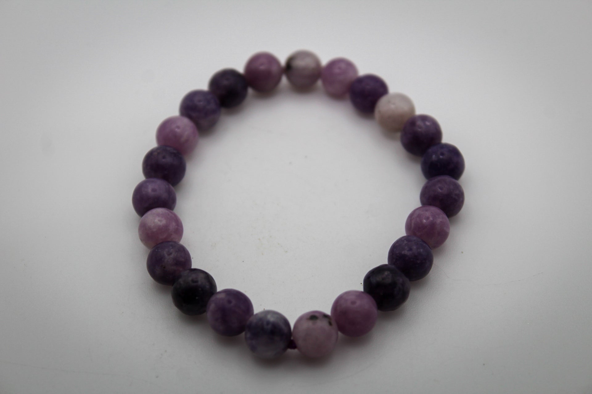 A bracelet made of purple lepidolite gemstone beads that are 8mm.