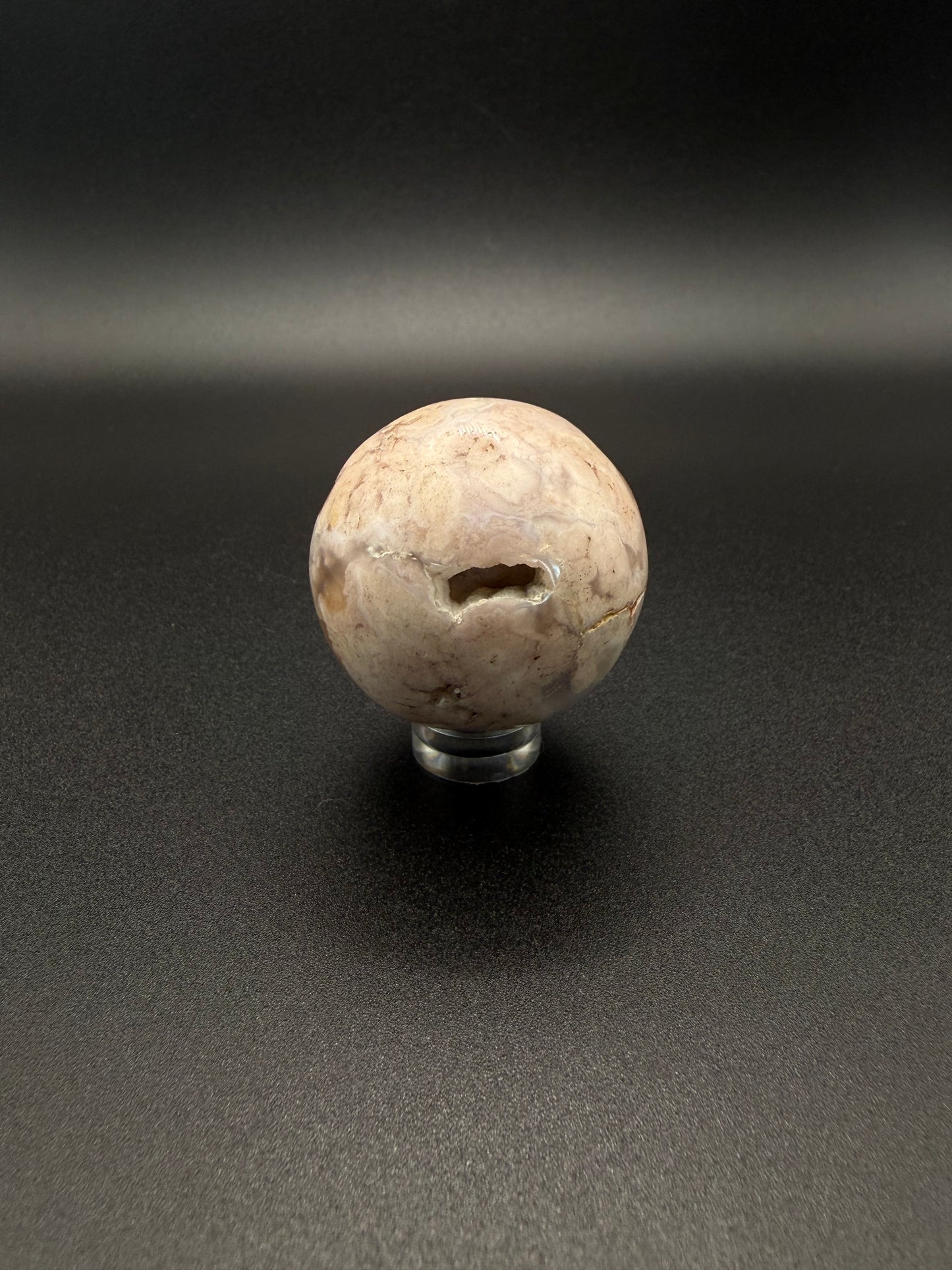 Flower agate polished crystal in the shape of a sphere.