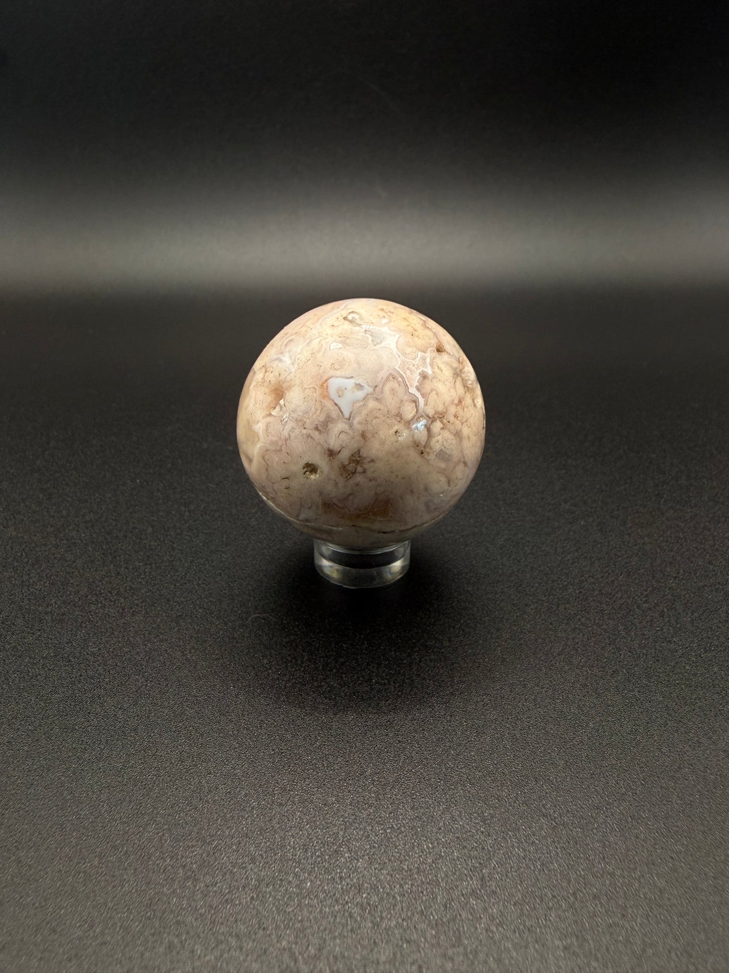Flower agate polished crystal in the shape of a sphere.
