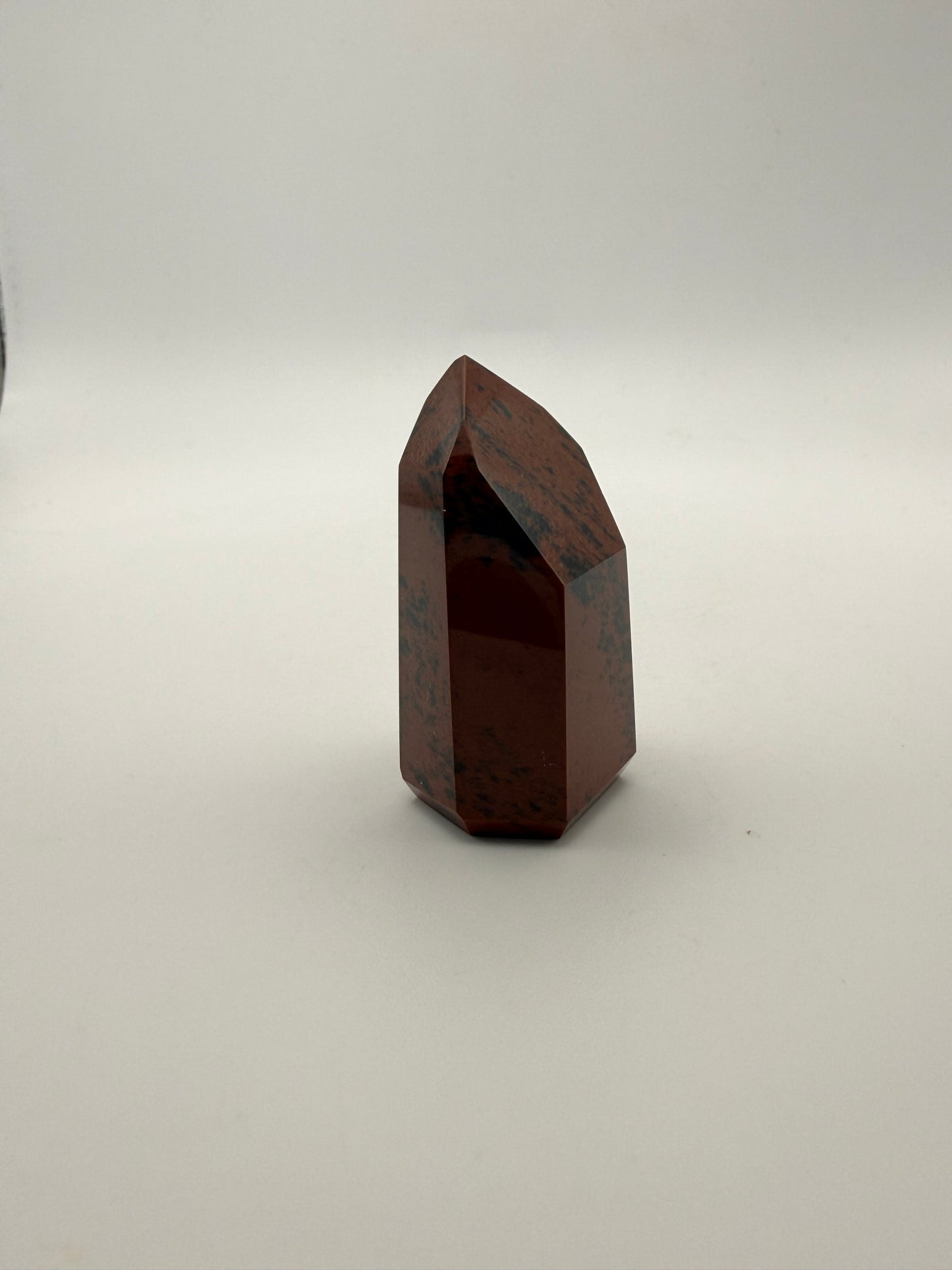 Polished mahogany obsidian tower with six sides.