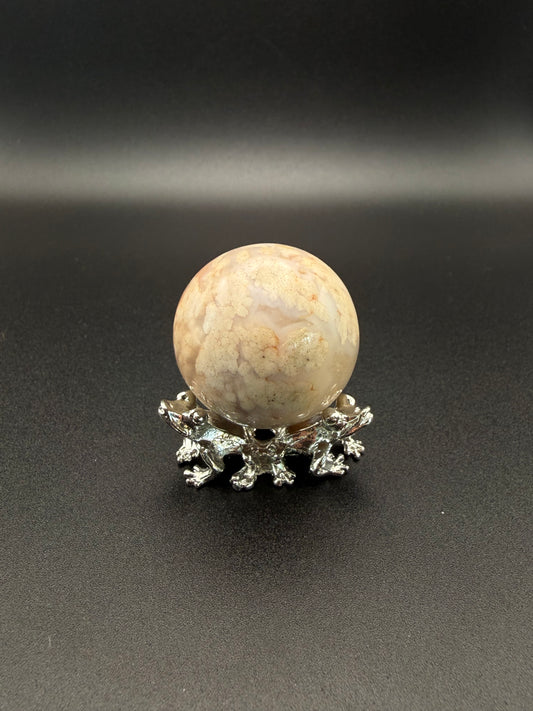 Flower agate polished crystal in the shape of a sphere.