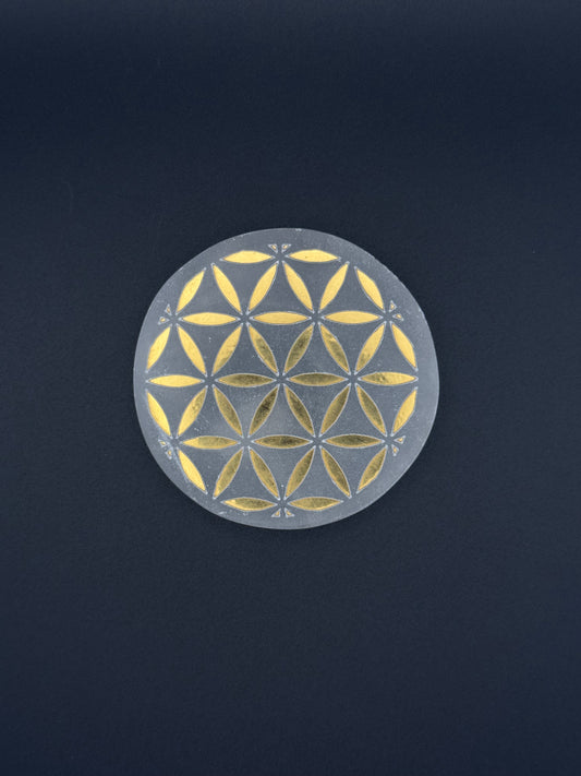 Selenite coaster with engraved flower of life symbol in gold.