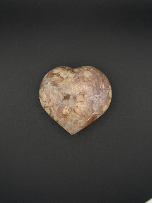 Flower agate polished crystal in the shape of a heart.