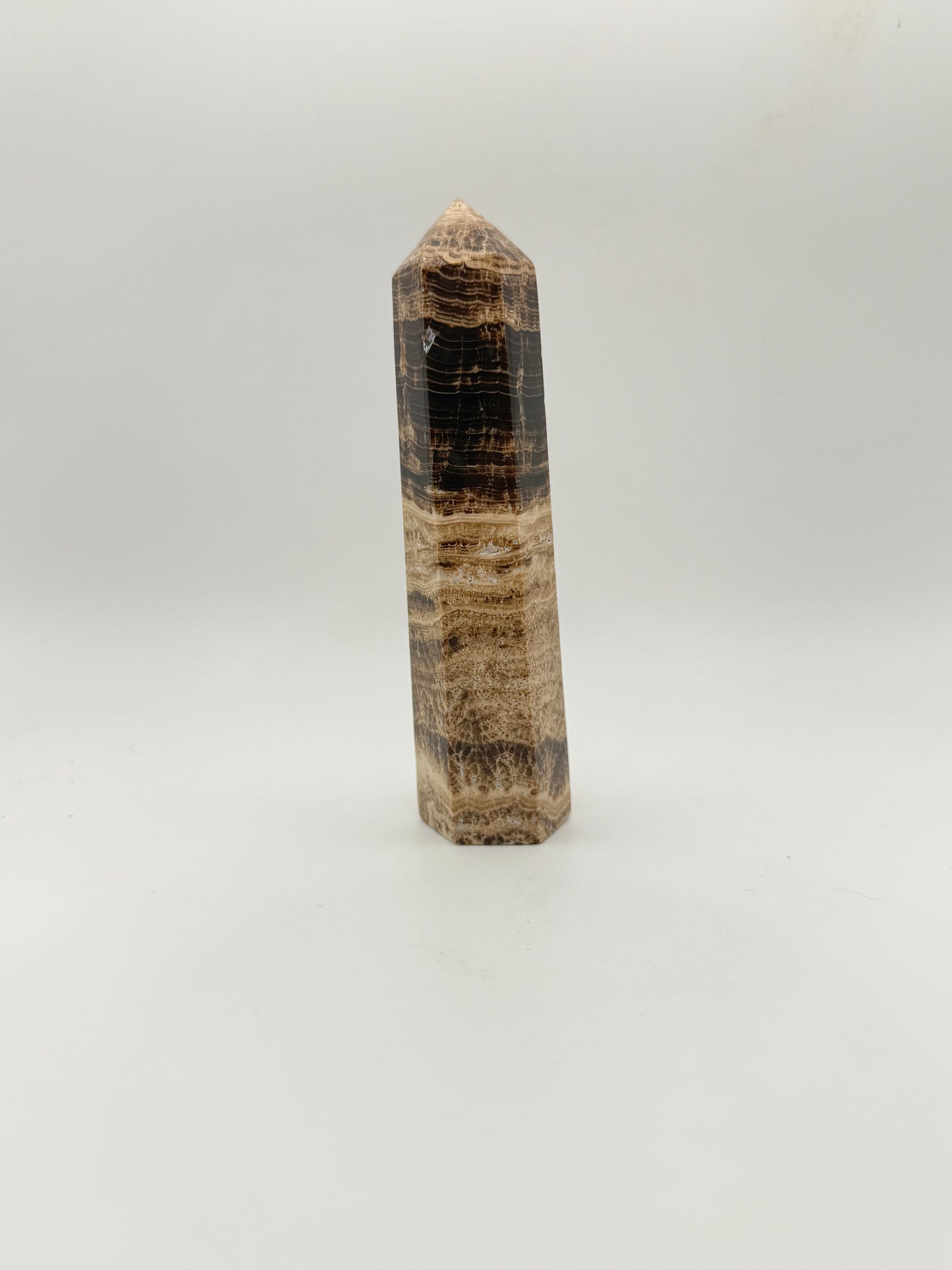 Polished chocolate calcite crystal tower. about 5 inches tall.