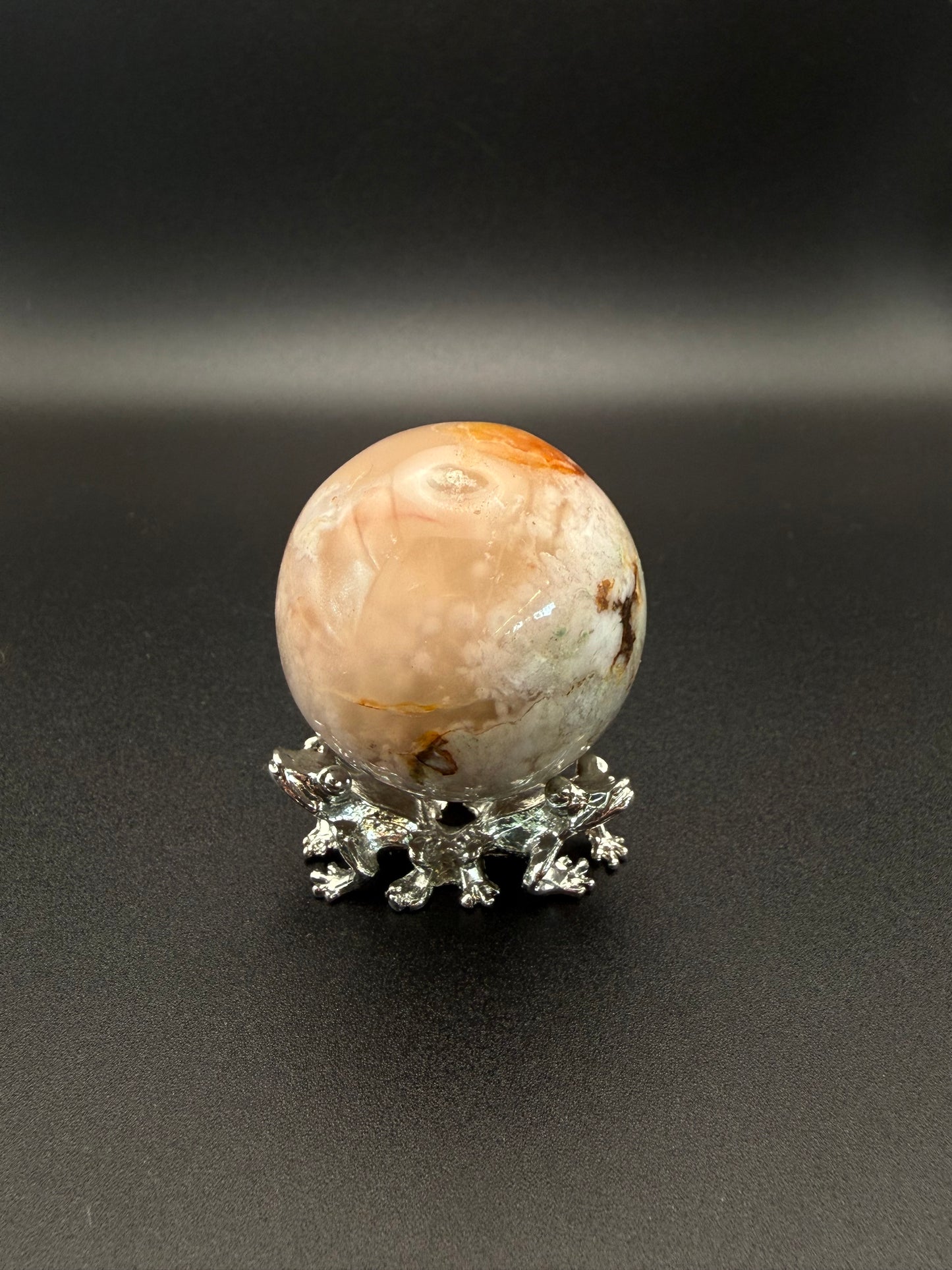 Flower agate polished crystal in the shape of a sphere.