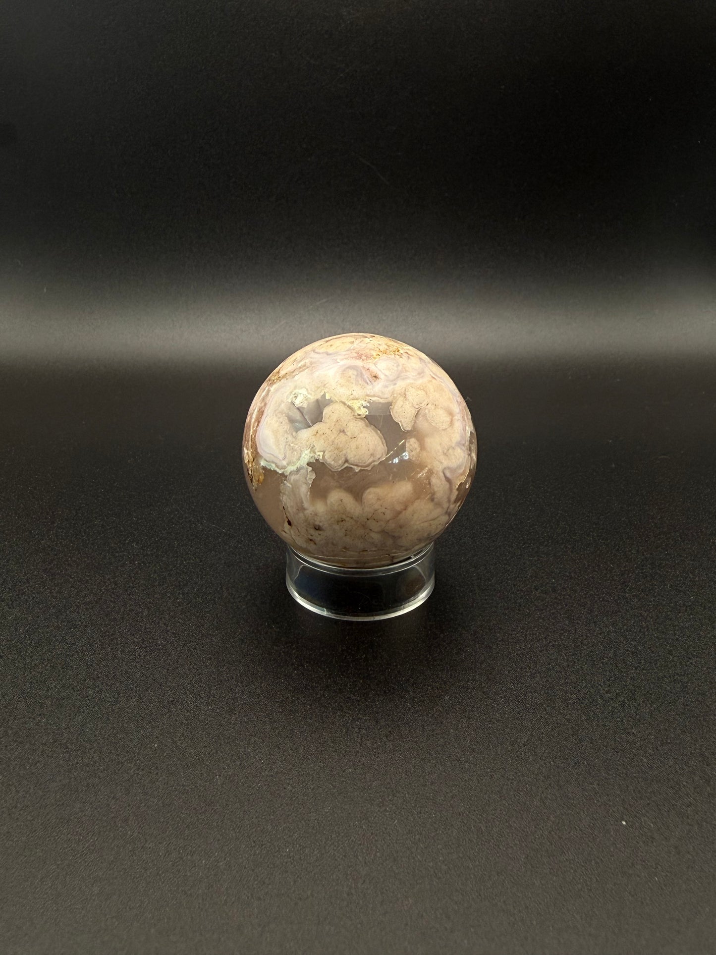 Flower agate polished crystal in the shape of a sphere.