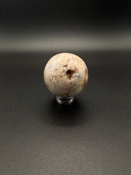 Flower agate polished crystal in the shape of a sphere.