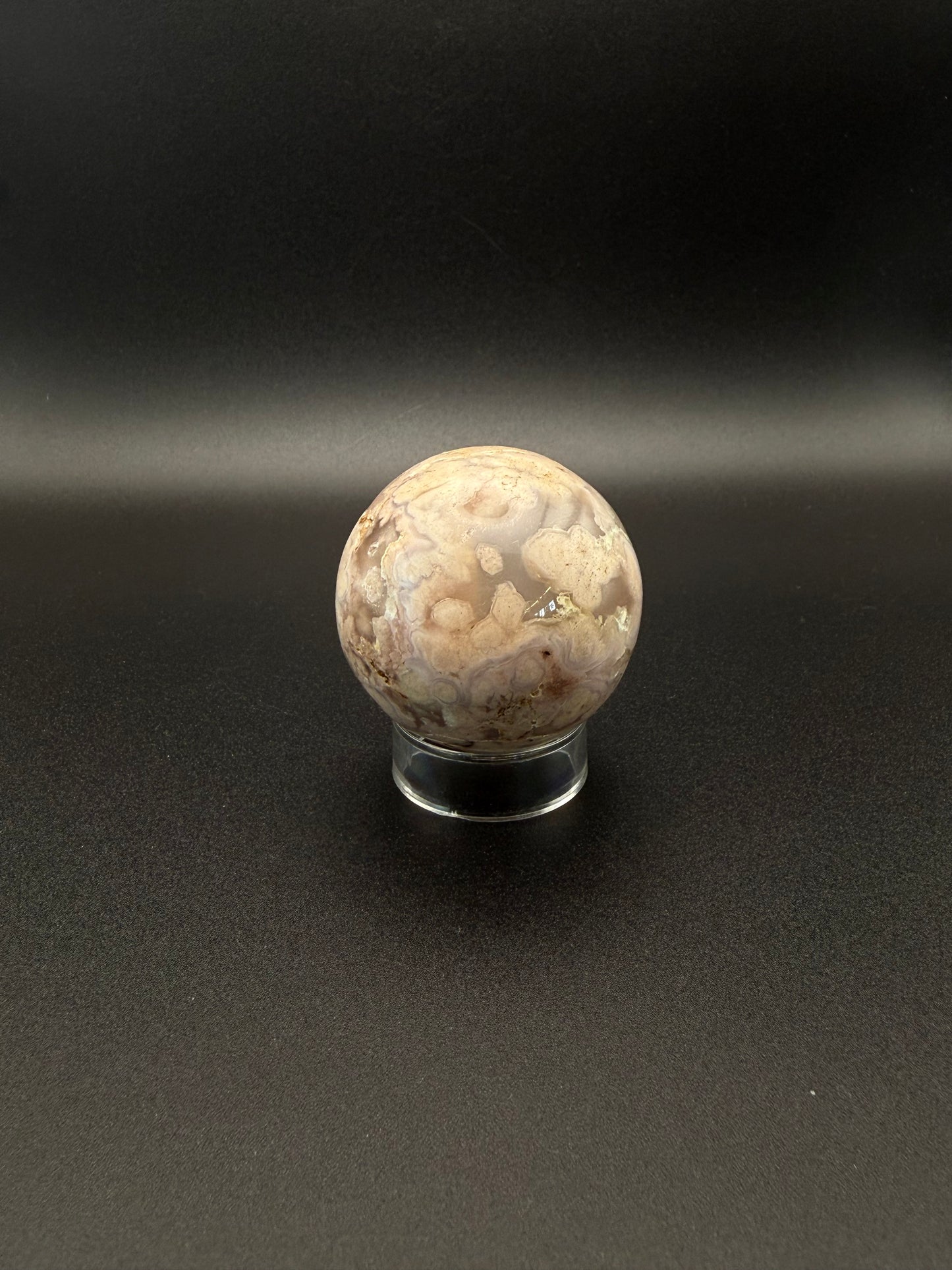 Flower agate polished crystal in the shape of a sphere.