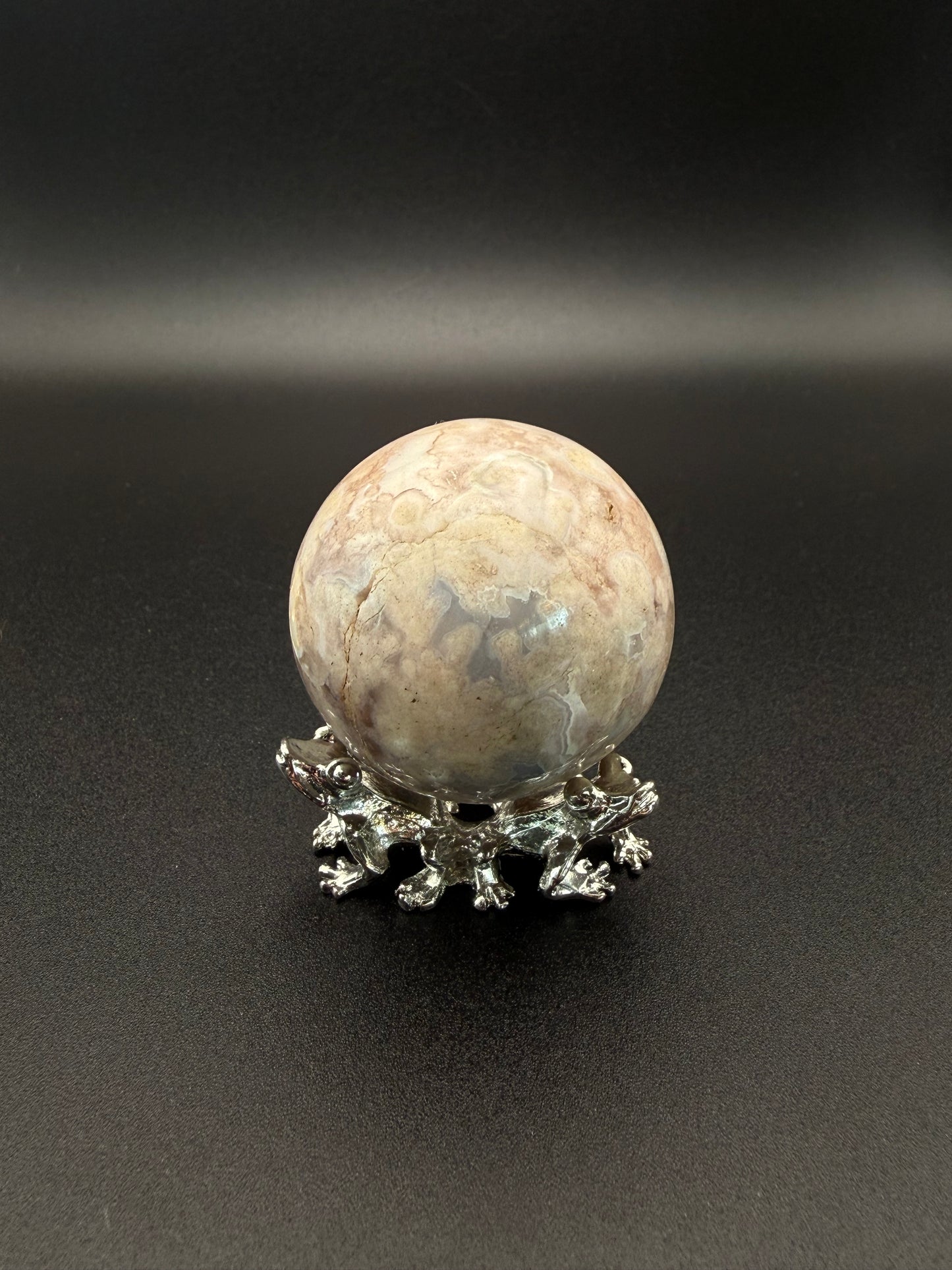 Flower agate polished crystal in the shape of a sphere.