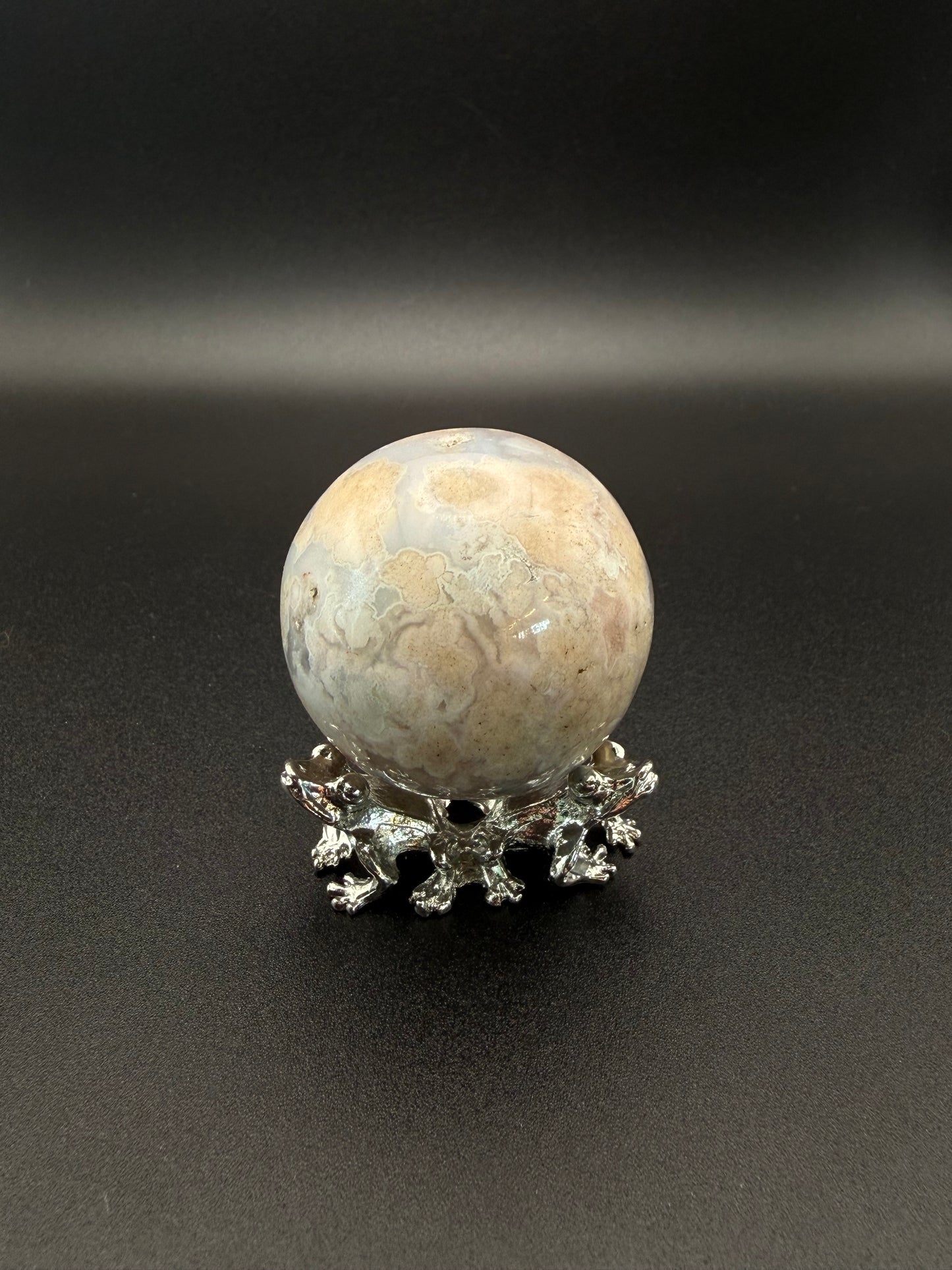 Flower agate polished crystal in the shape of a sphere.