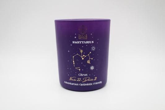 A purple candle with a Sagittarius sign design, featuring a centaur, stars, and a crescent moon.