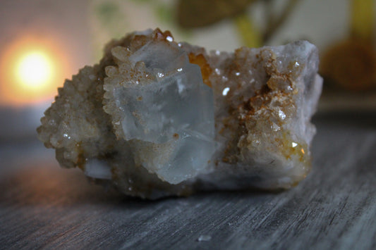 Raw fluorite crystal cluster blue in color with calcite growth on top.