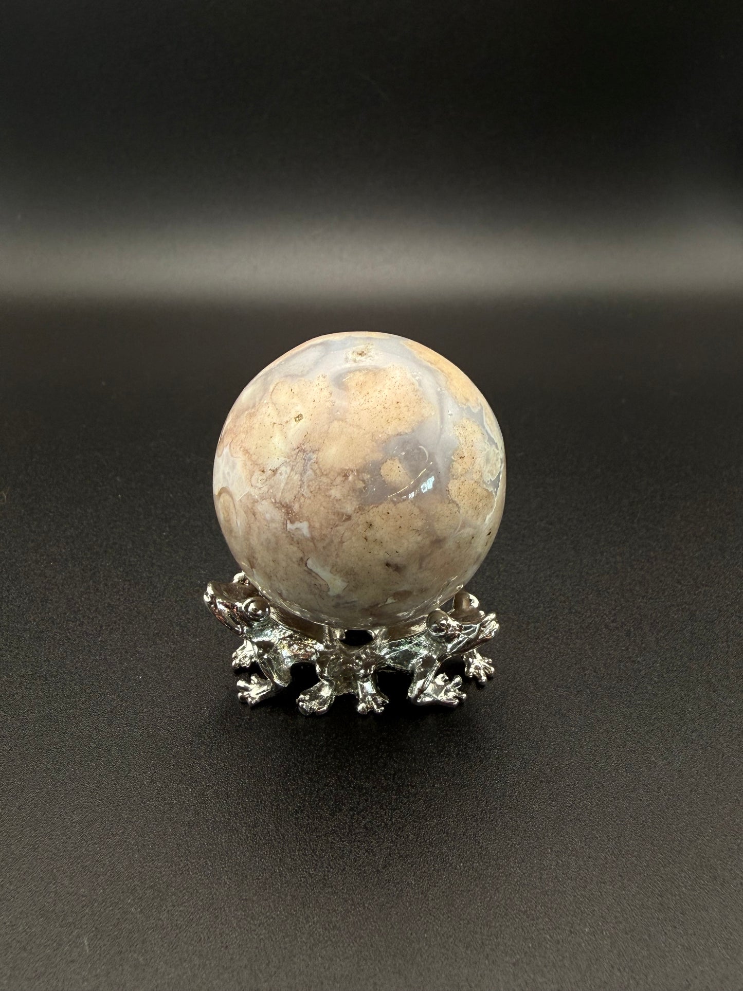 Flower agate polished crystal in the shape of a sphere.