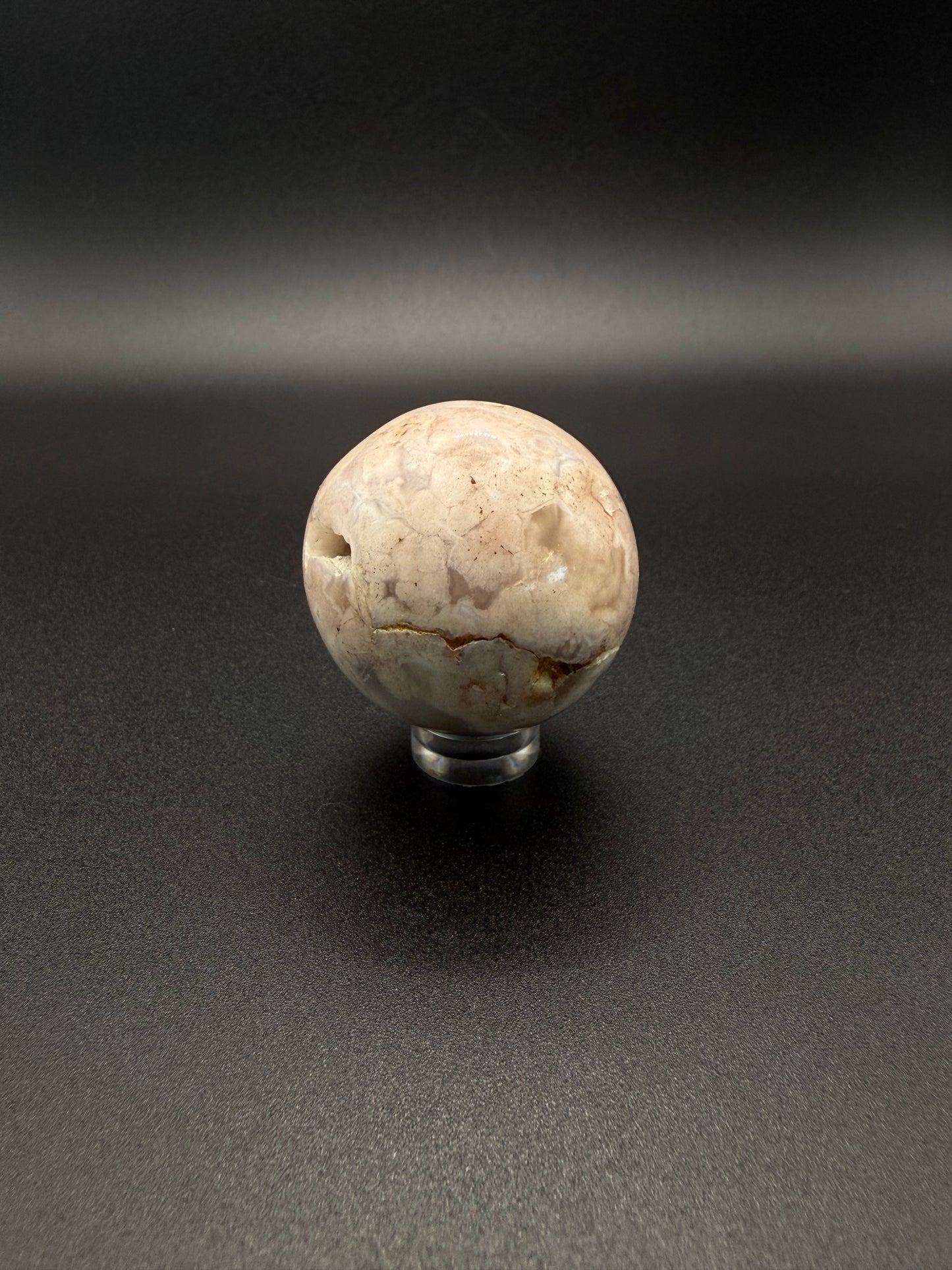 Flower agate polished crystal in the shape of a sphere.