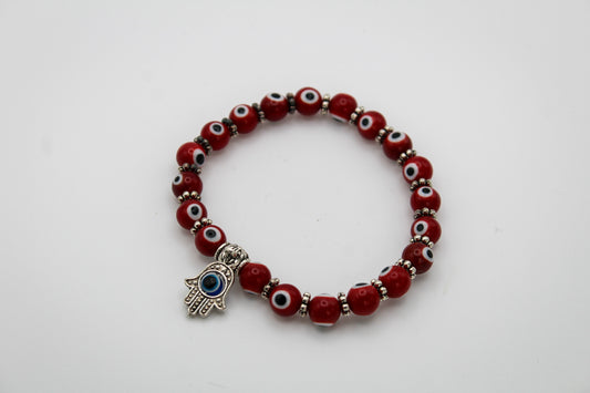 A collection of red colored evil eye bracelets with a hasma and evil eye charm.