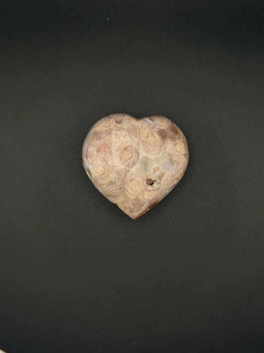 Flower agate polished crystal in the shape of a heart.