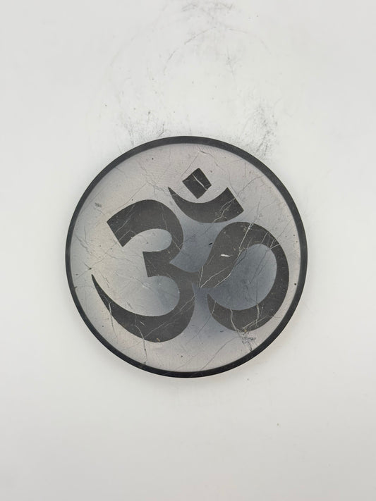 Shungite coaster with OM symbol engraved on it.