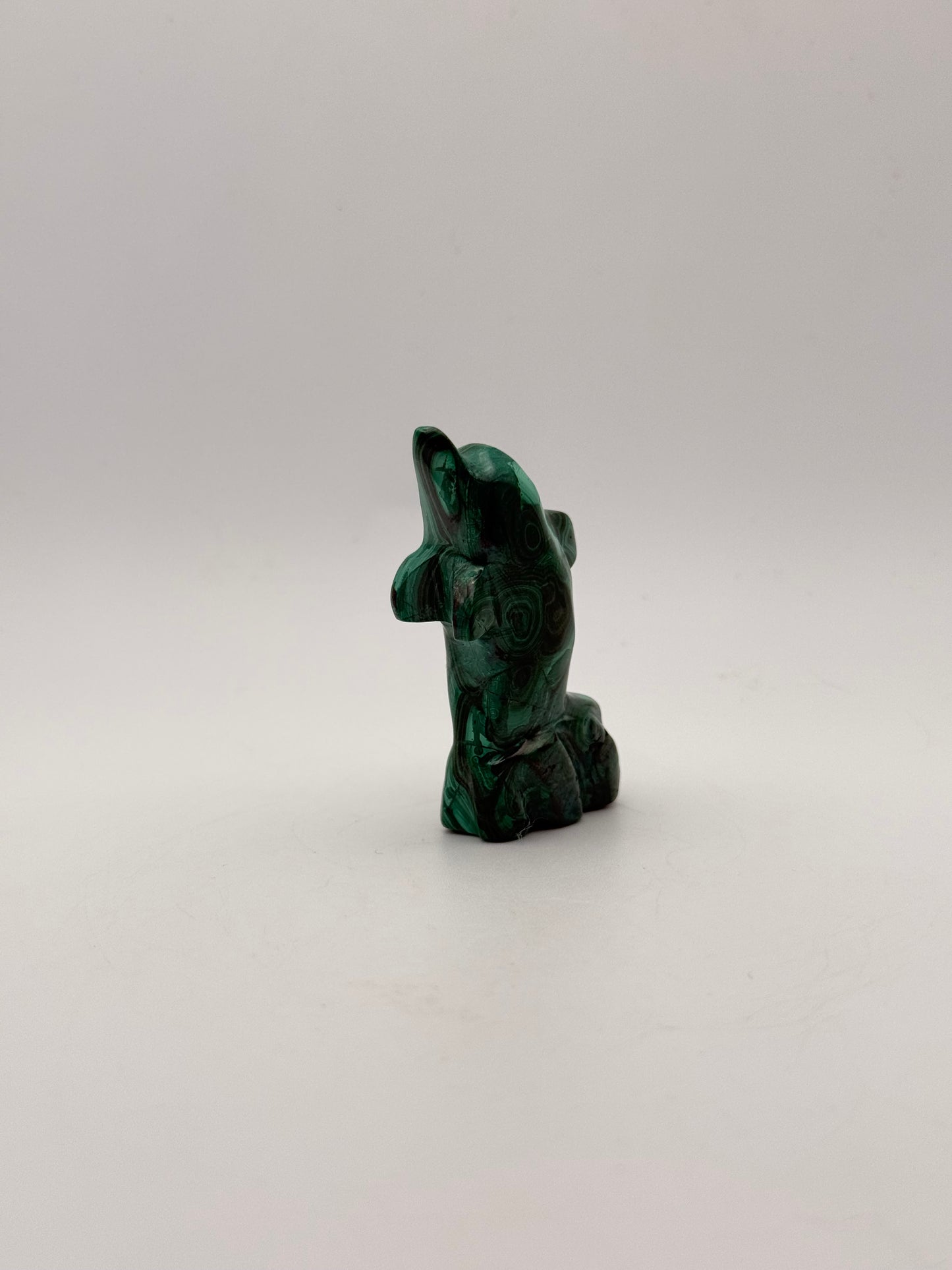 Polished malachite dolphin carving.