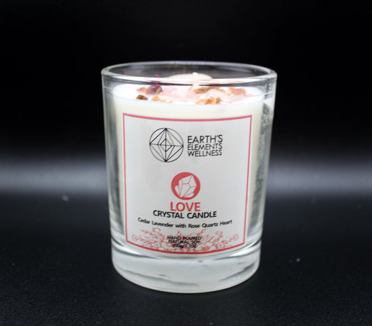 A clear glass candle with a decorative bow on top, next to its packaging box. Scents of cedar and lavender, with a rose quartz heart.