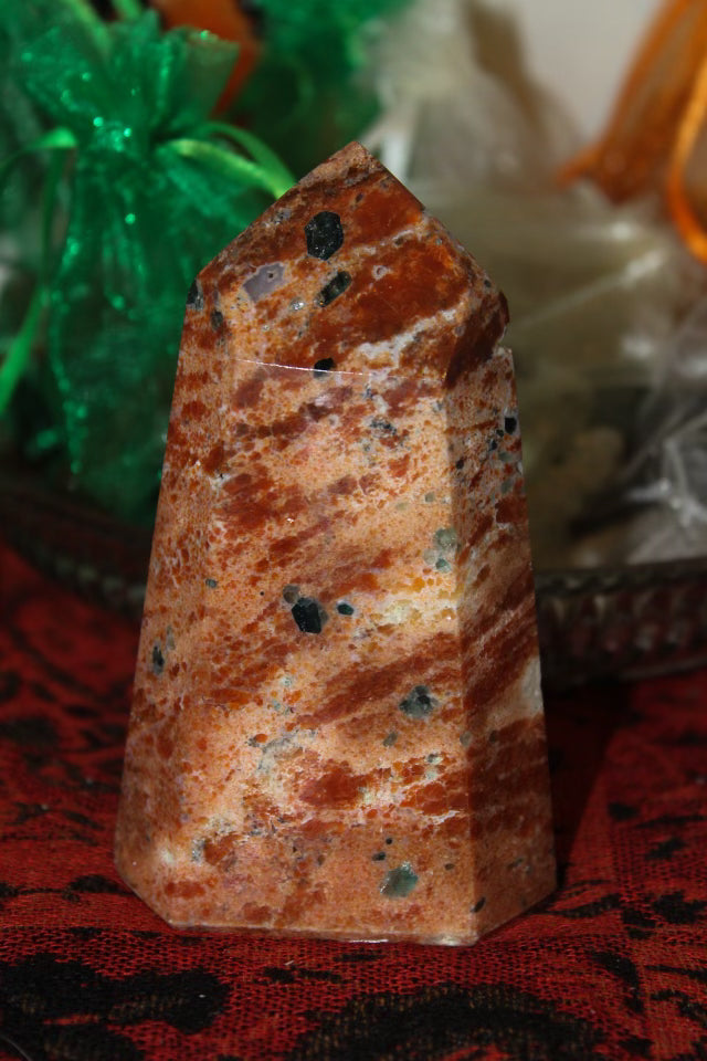 An orange calcite crystal with apatite tower.