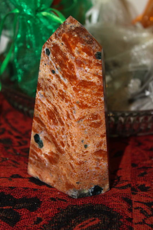 An orange calcite crystal with apatite tower.