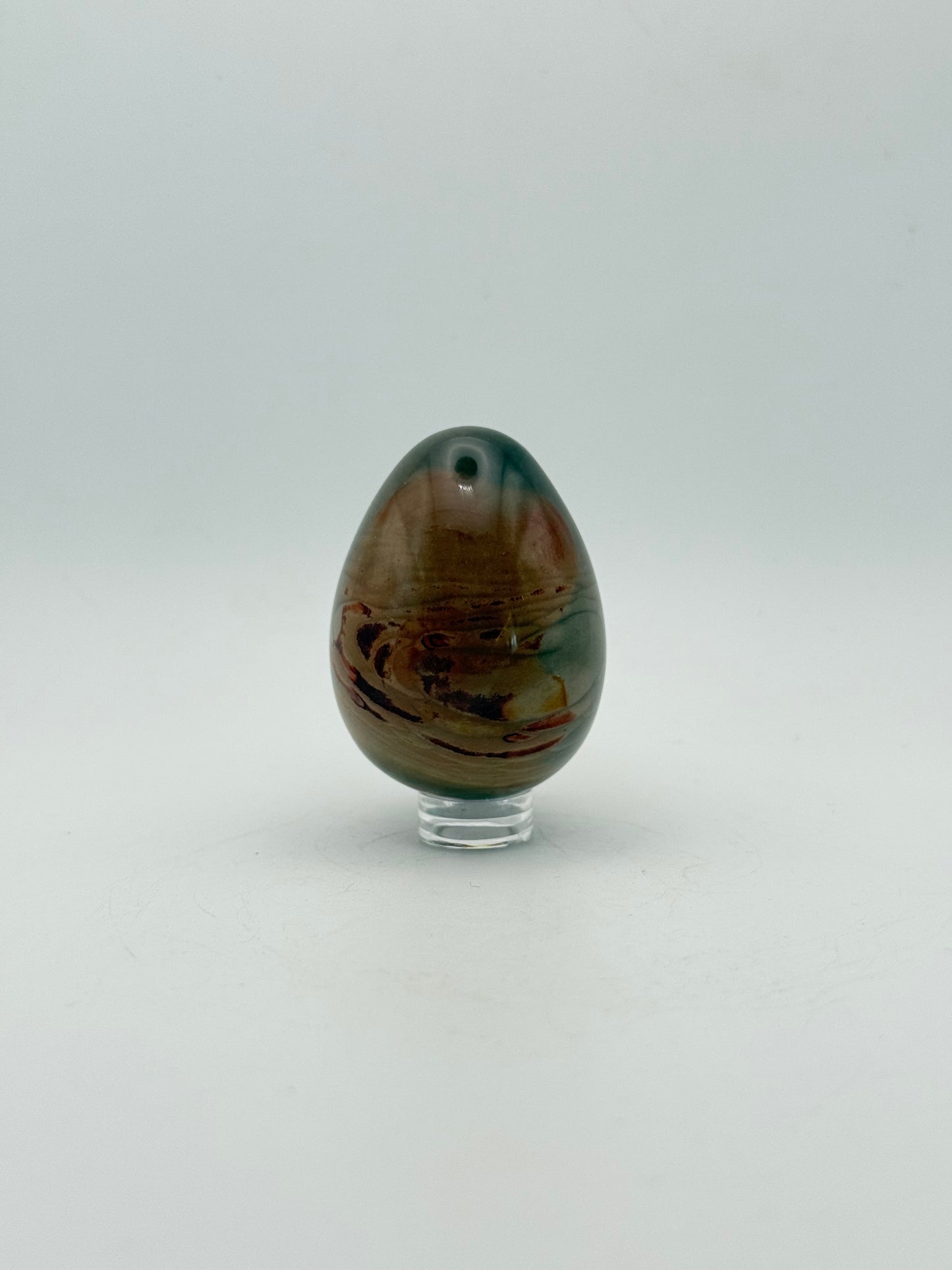 Polished polychrome jasper shaped into an egg.