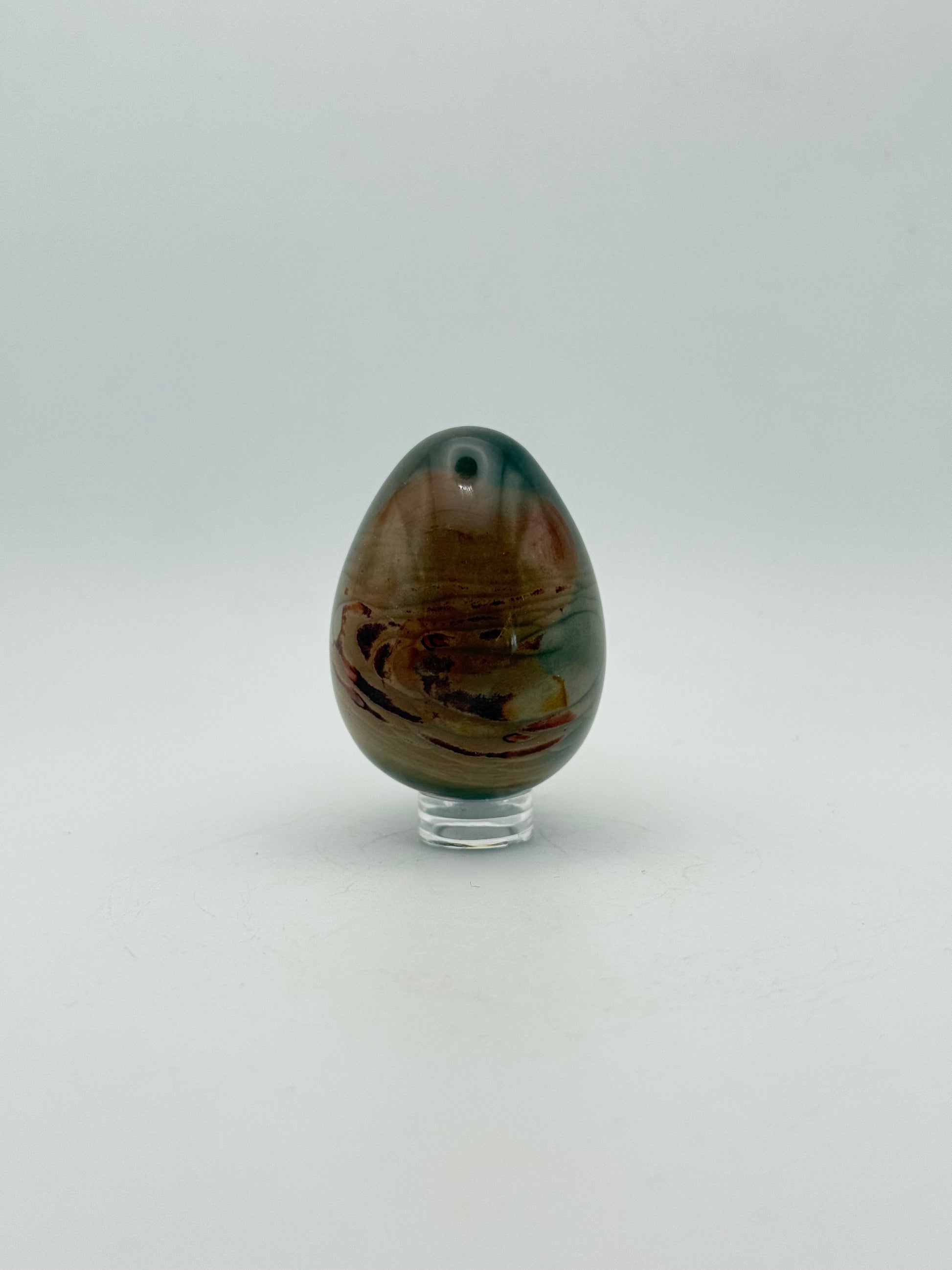 Polished polychrome jasper shaped into an egg.