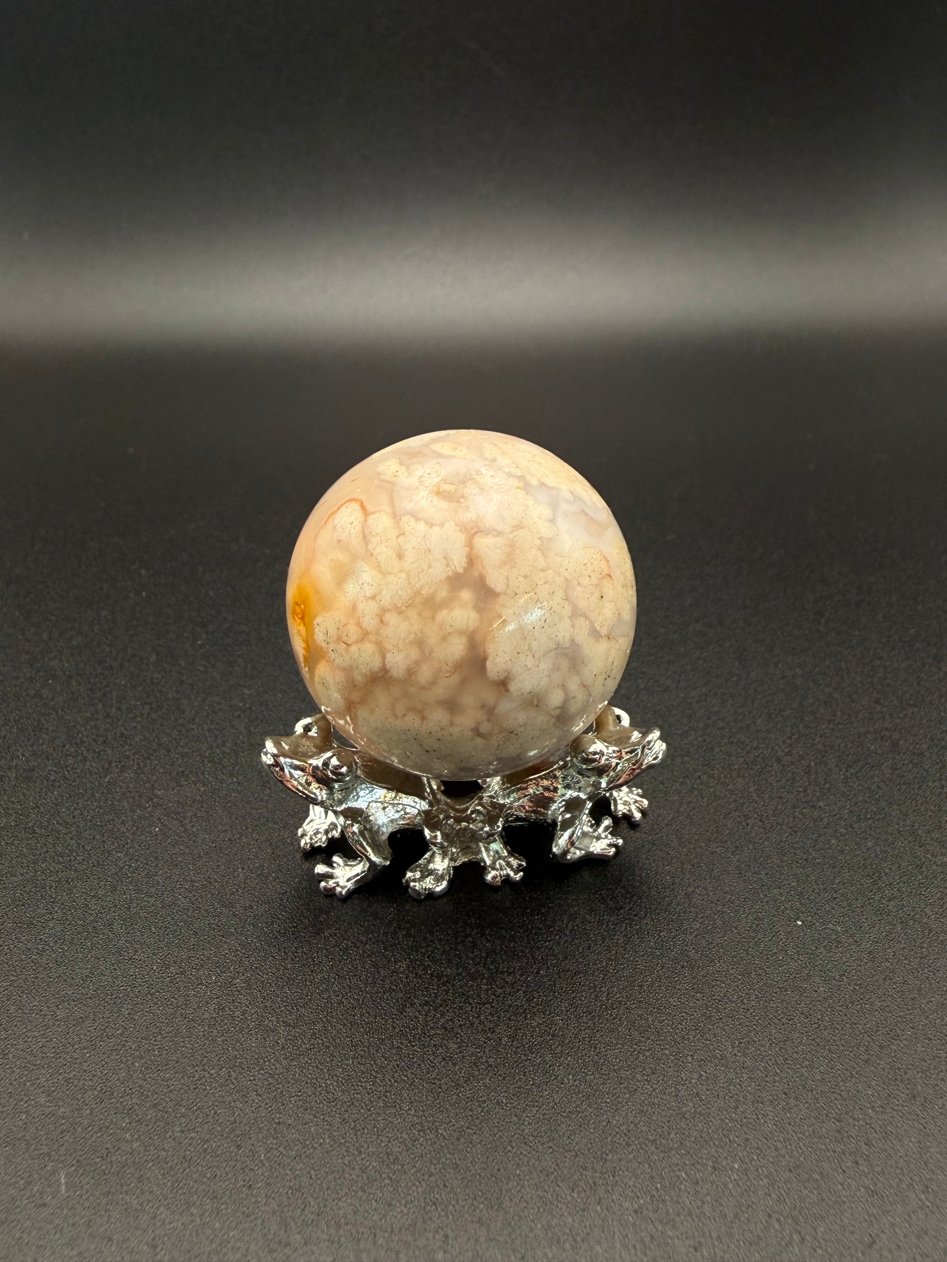 Flower agate polished crystal in the shape of a sphere.