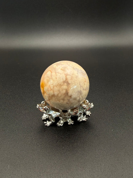 Flower agate polished crystal in the shape of a sphere.