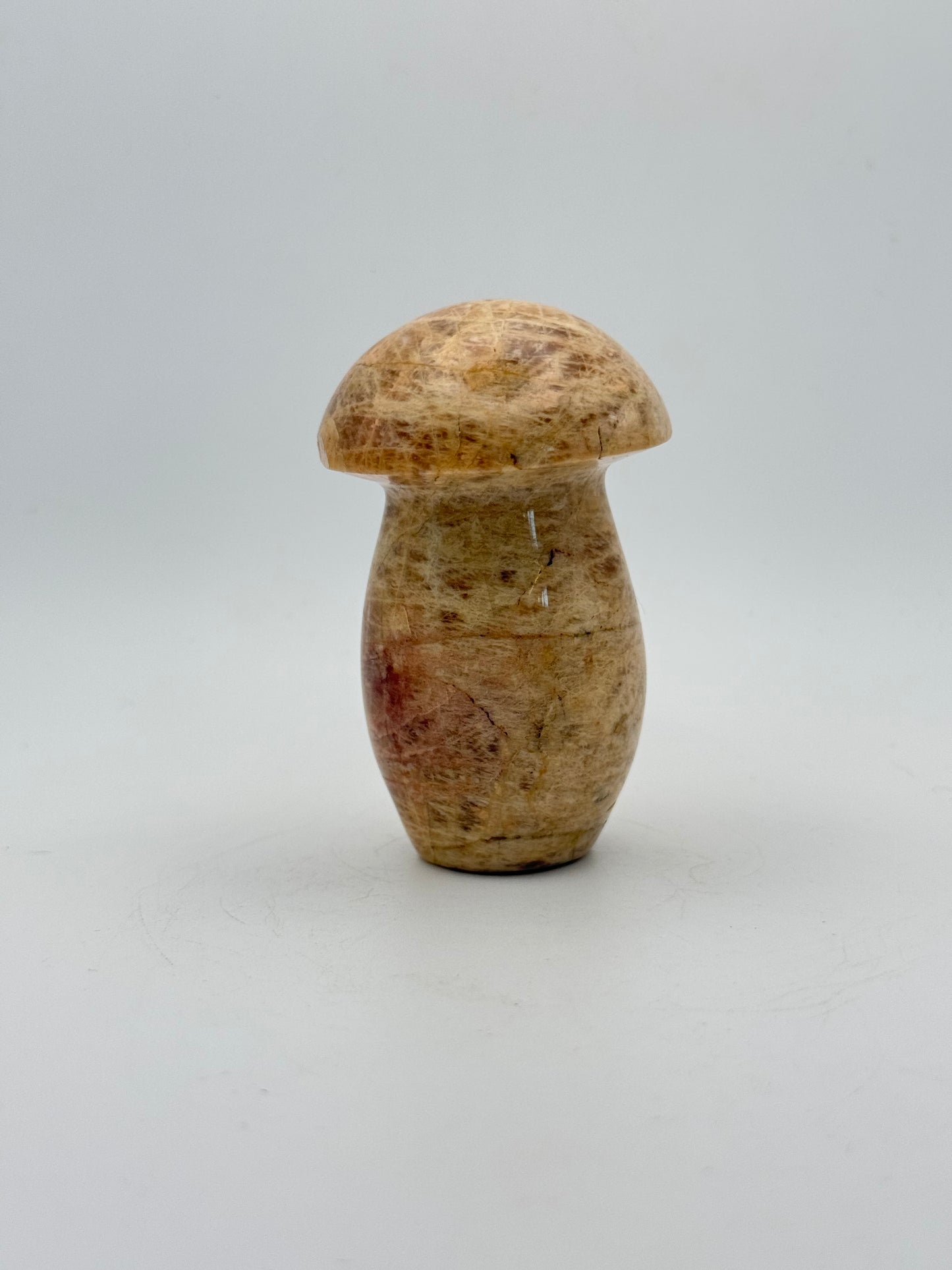 Polished yellow moonstone in the shape of a mushroom.