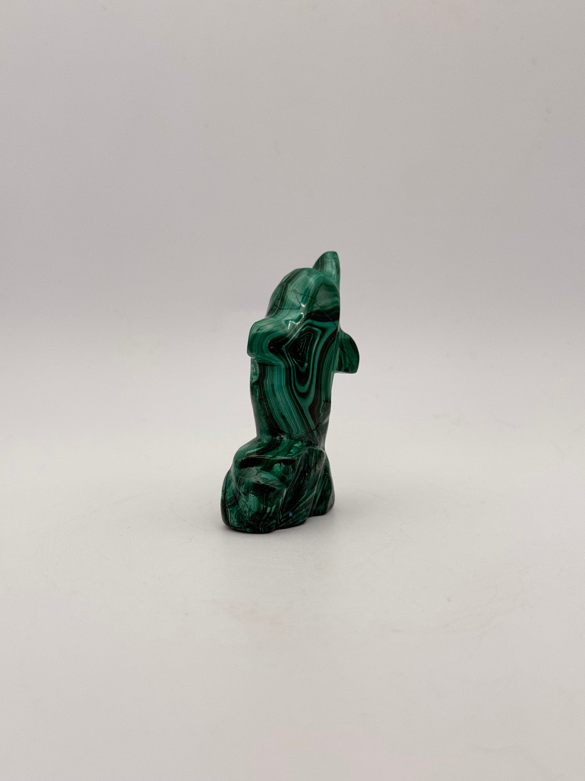 Polished malachite dolphin carving.