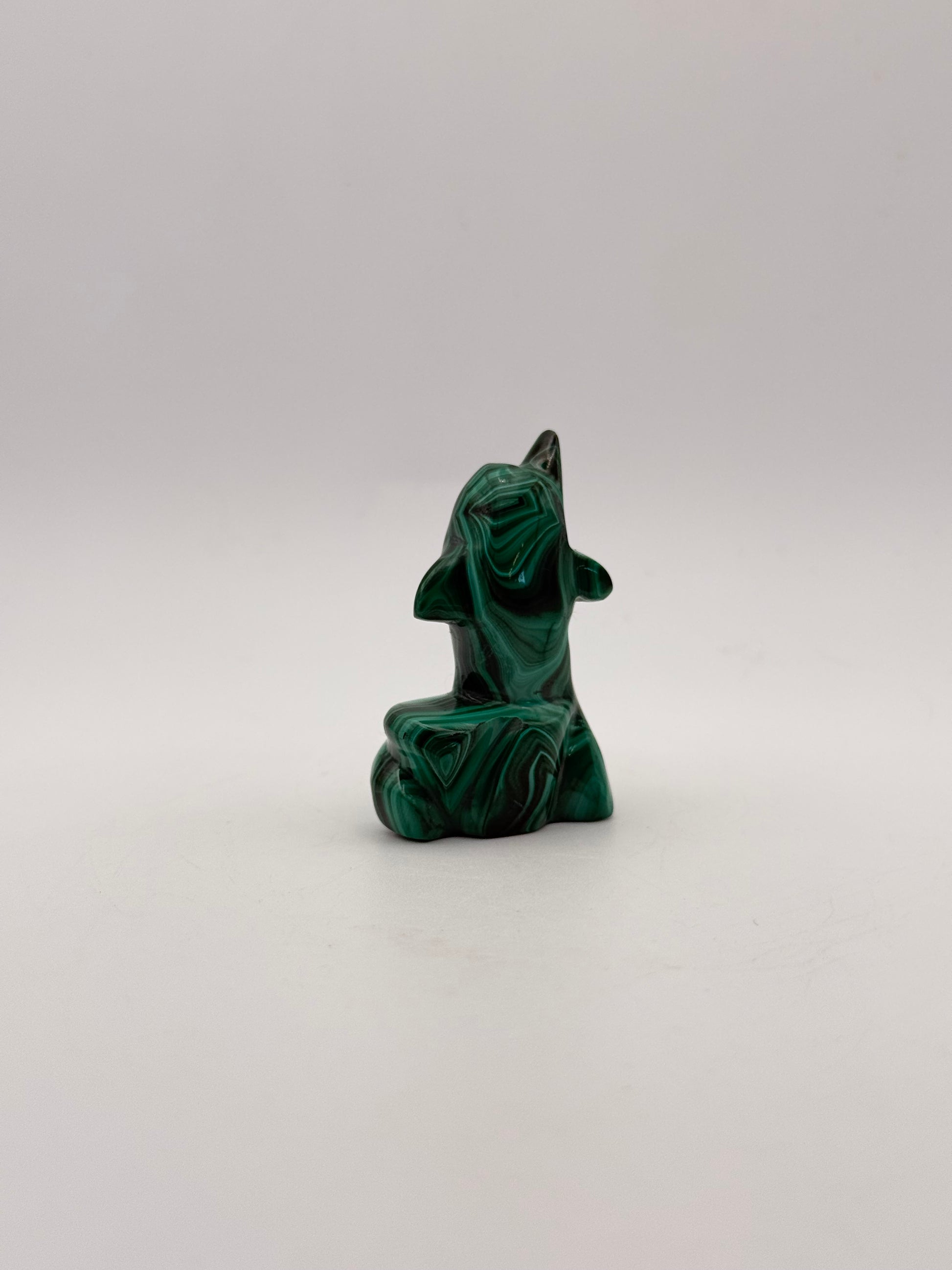 Polished malachite dolphin carving.