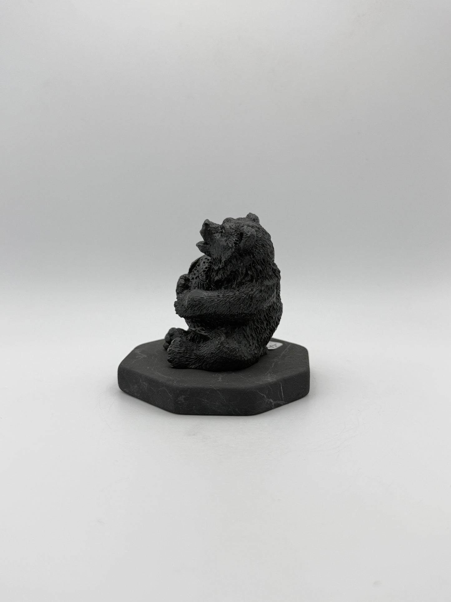 Shungite carving of a bear holding a fish.