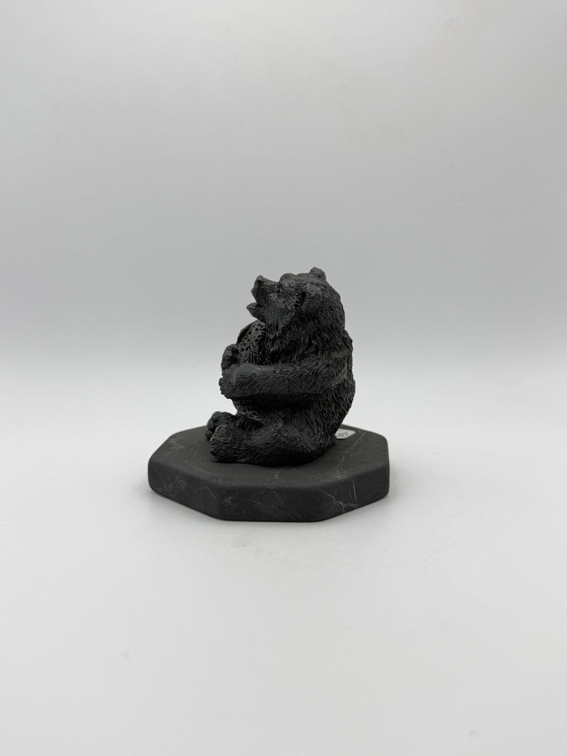Shungite carving of a bear holding a fish.