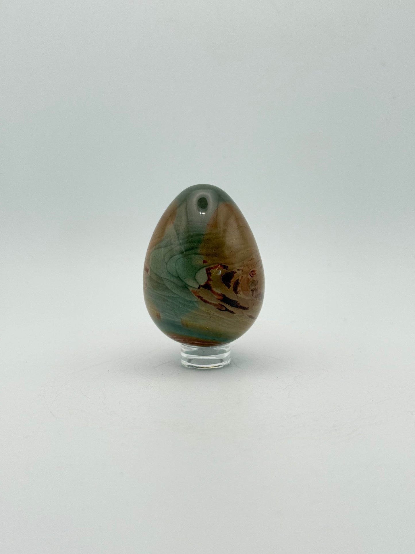 Polished polychrome jasper shaped into an egg.