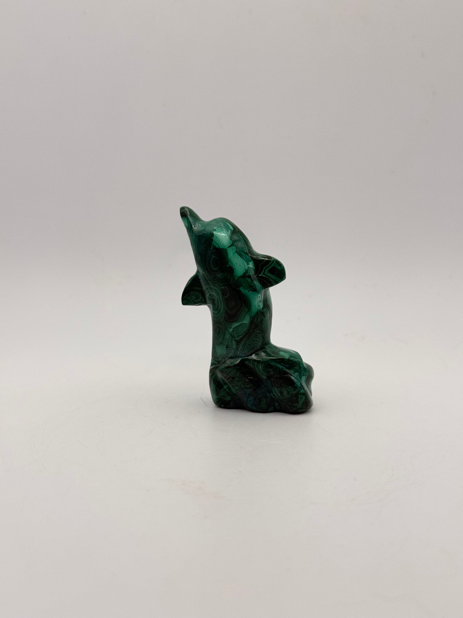 Polished malachite dolphin carving.