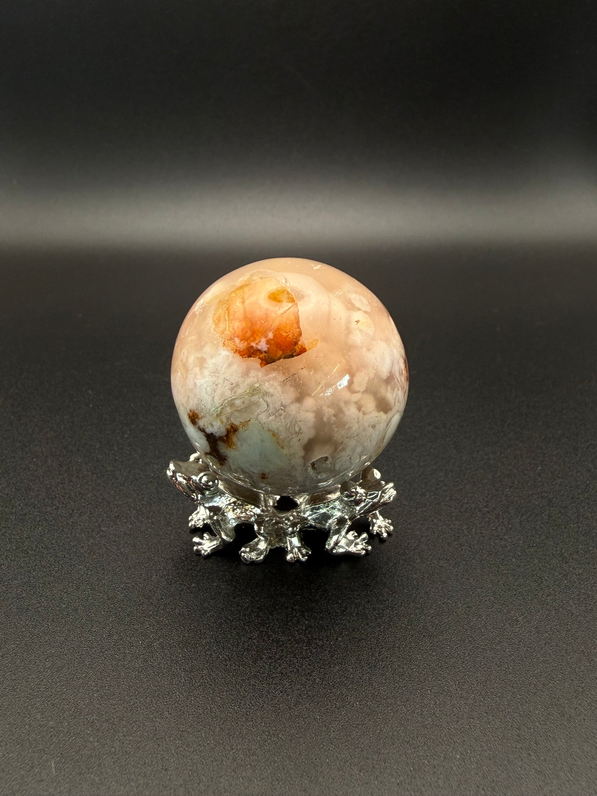 Flower agate polished crystal in the shape of a sphere.