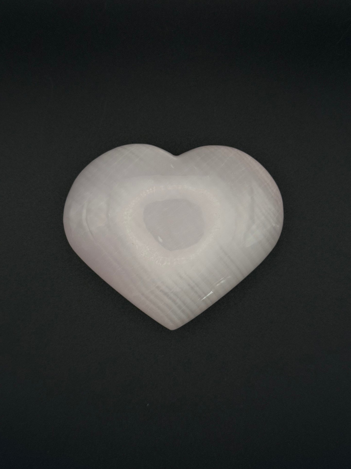 Polished pink calcite heart. Pink calcite glows under uv light.