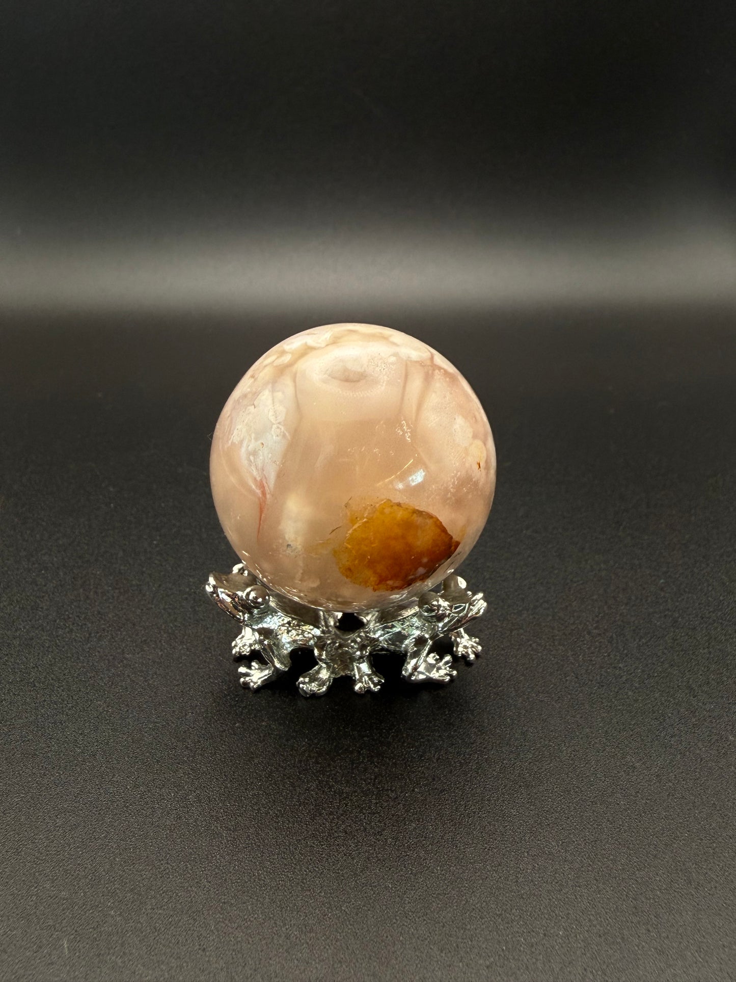 Flower agate polished crystal in the shape of a sphere.