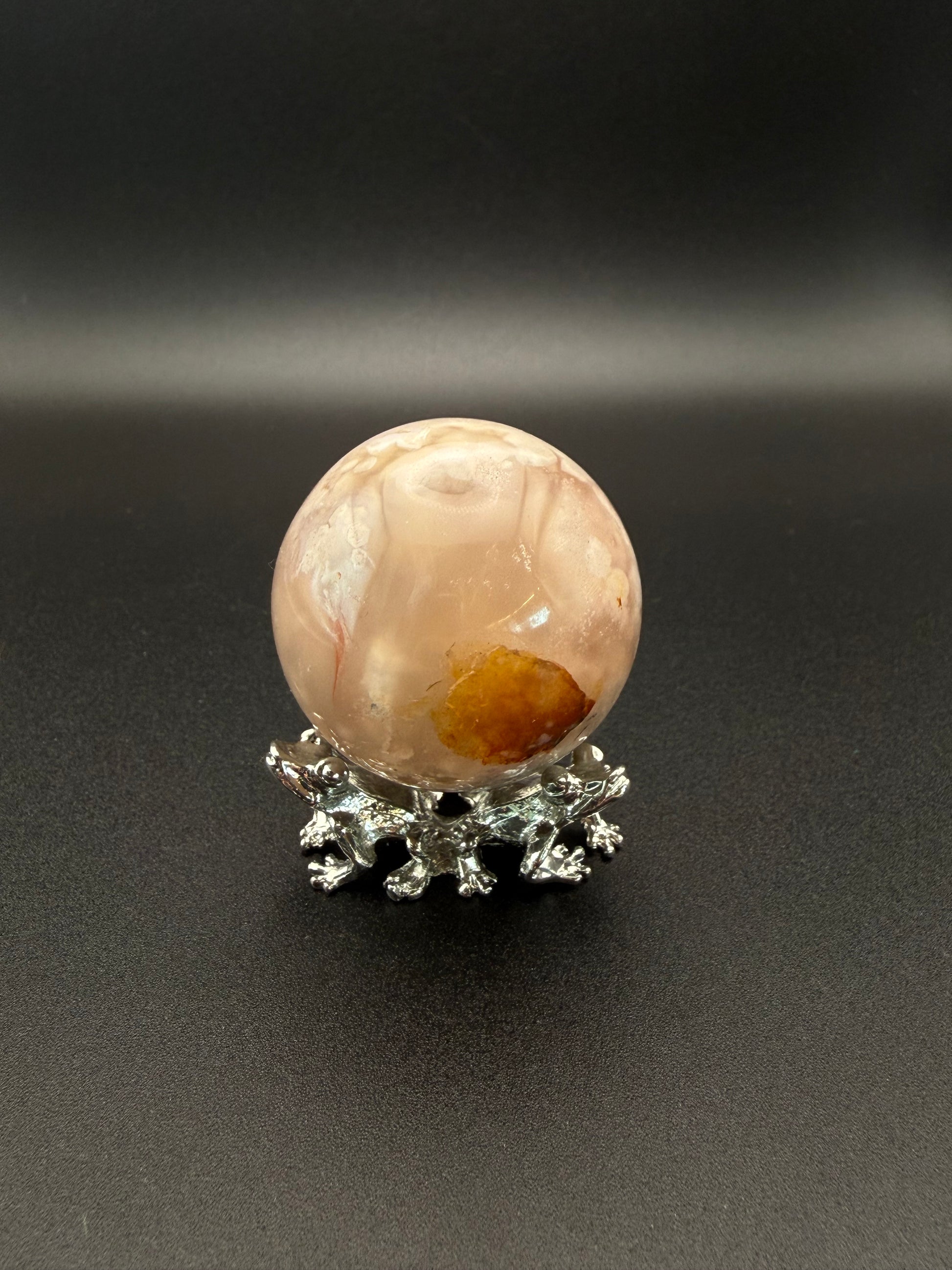 Flower agate polished crystal in the shape of a sphere.