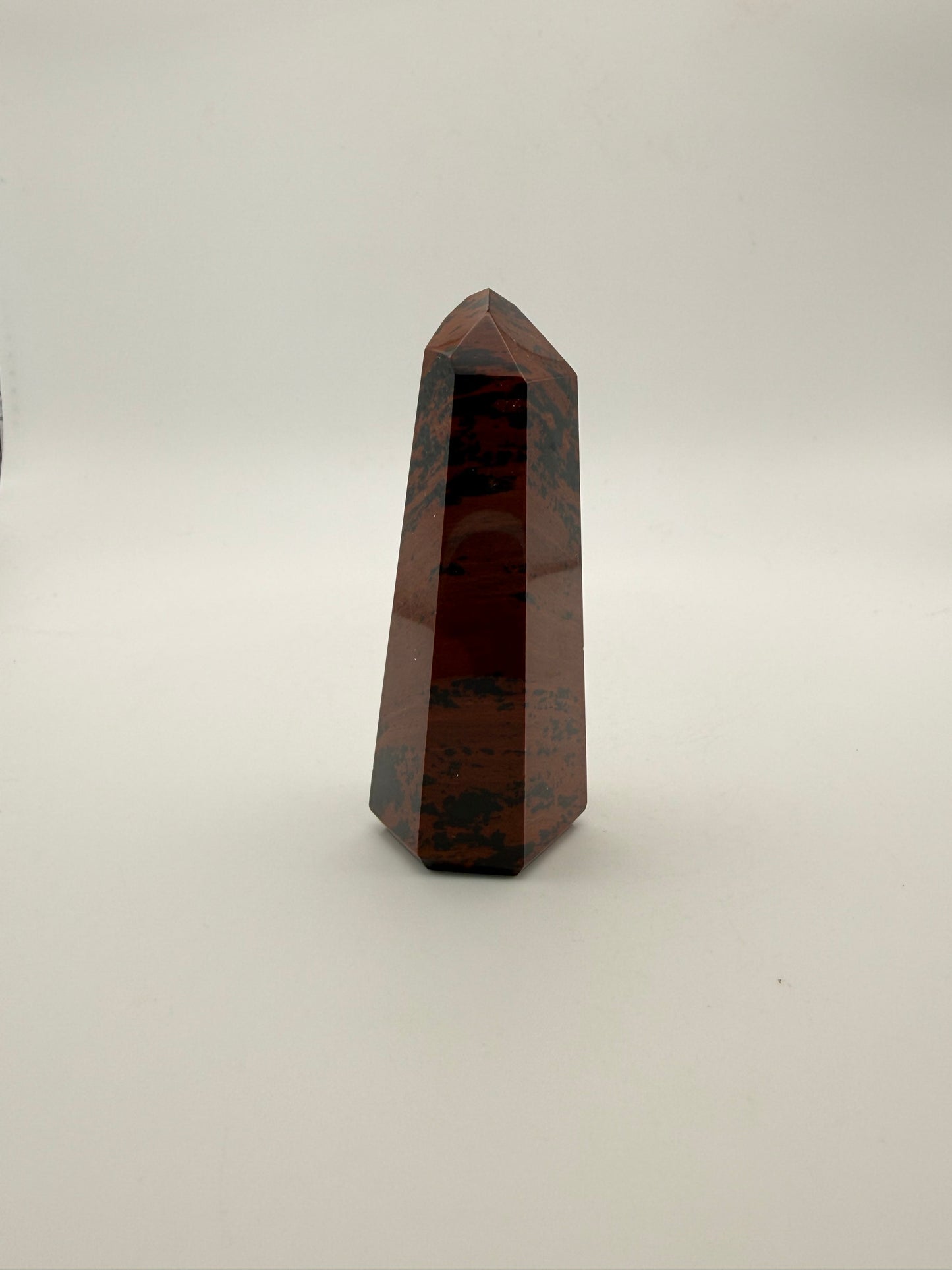 Polished mahogany obsidian tower with six sides.