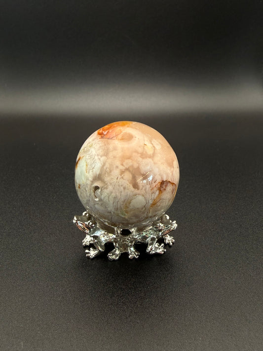 Flower agate polished crystal in the shape of a sphere.