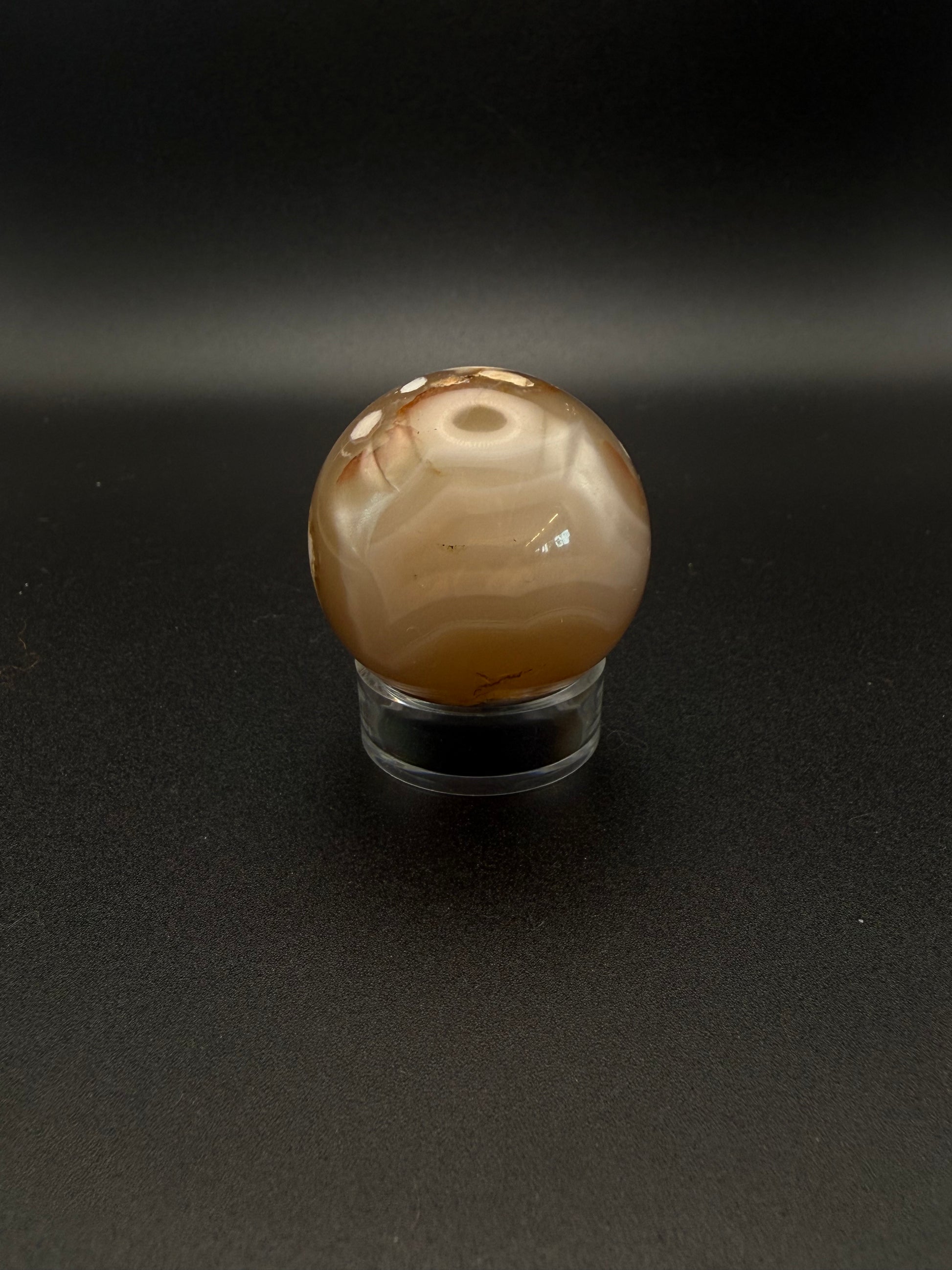 Flower agate polished crystal in the shape of a sphere.
